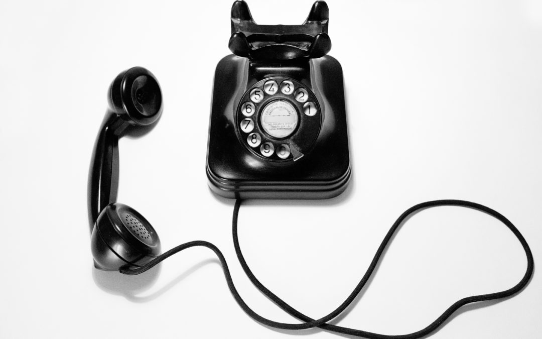 black rotary dial phone on white surface